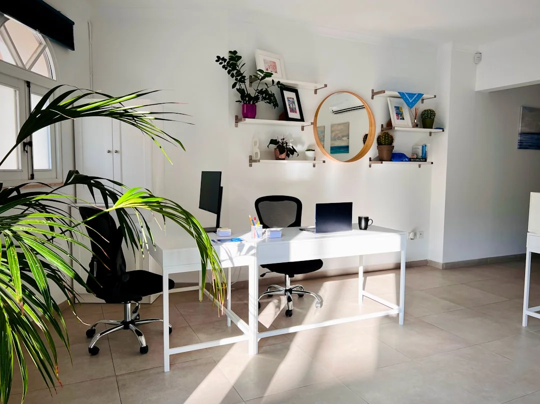 A clean and organized home office desk with cleaning products, papers, and storage baskets.